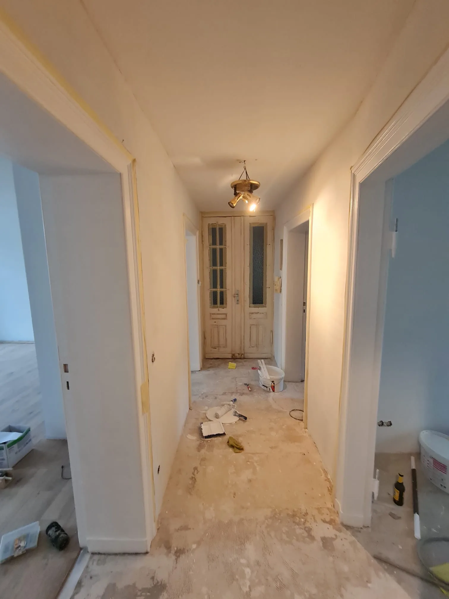Altbau-Diele während der Renovierung — Rohboden mit Werkzeug, die originale Doppeltür mit Glaseinsätzen noch im Bestand