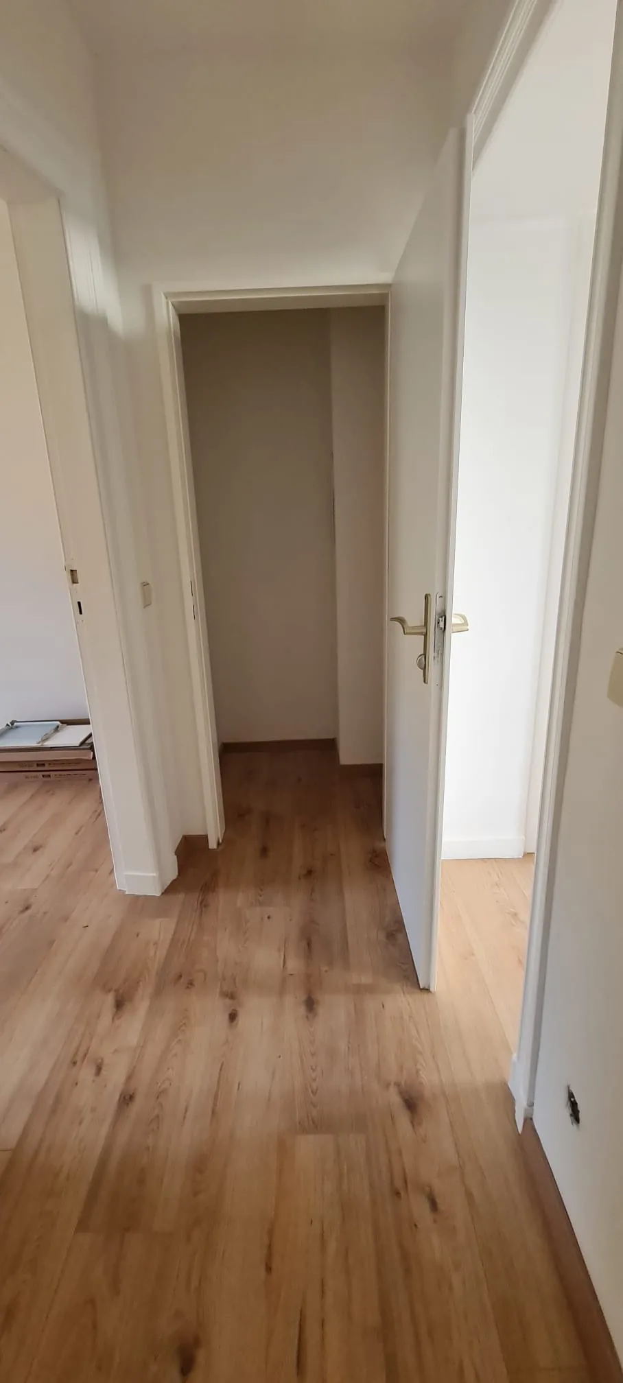 Diele nach der Renovierung — neuer Boden in Holzoptik, frisch gestrichene Wände