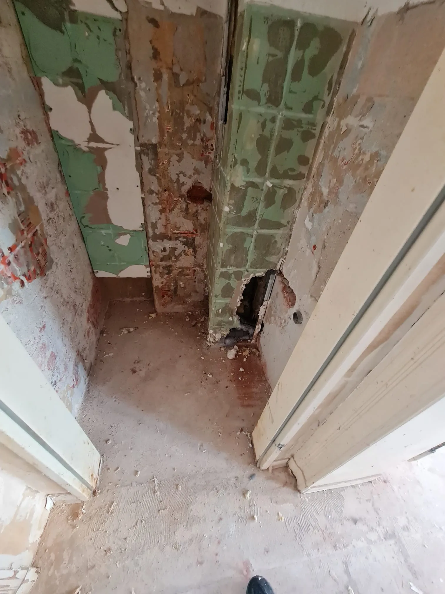 Diele im Rohzustand vor der Renovierung — alte Wandfliesen entfernt, Rohbau sichtbar