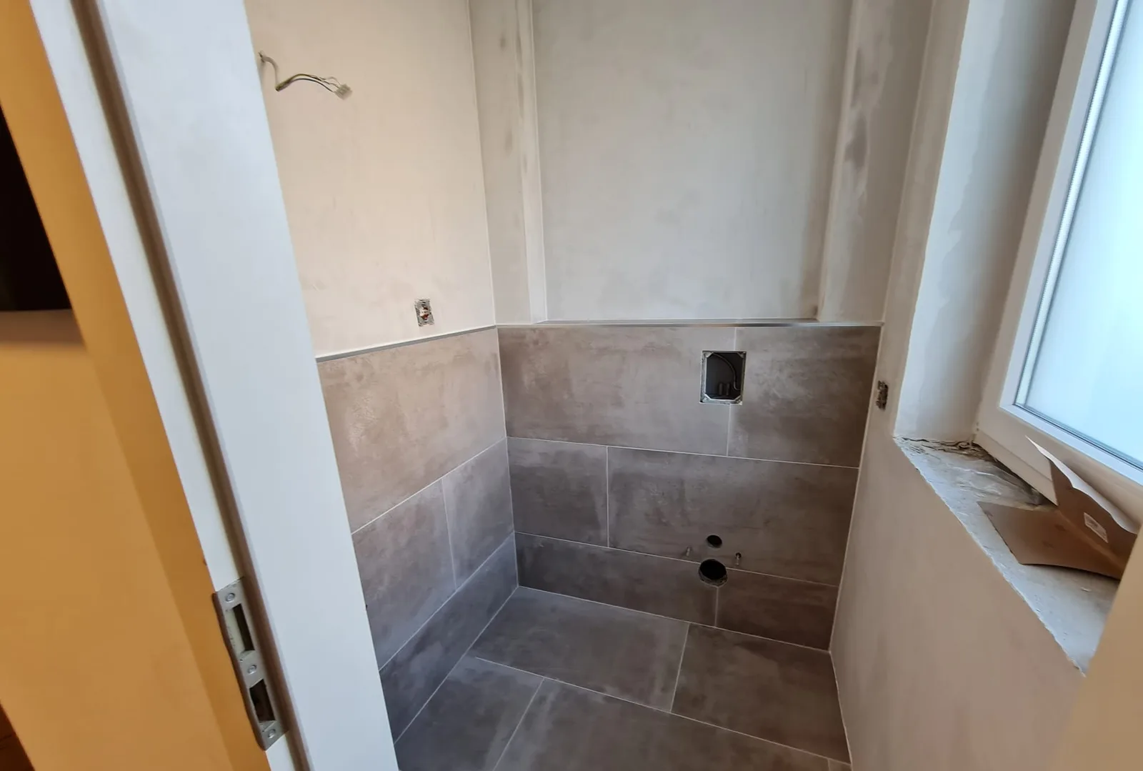 Das große Bad: WC-Nische in grauen Großformatfliesen