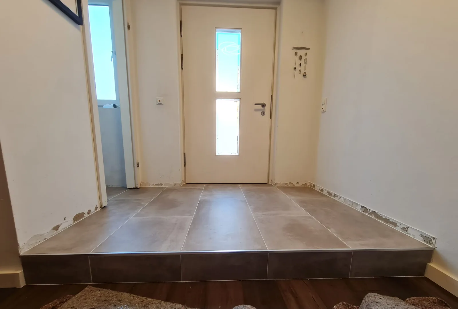 Der Aufgang zur Haustür im selben Projekt: großformatige Fliesen absolut eben verlegt, mit sauberer Schiene an der Stufenkante